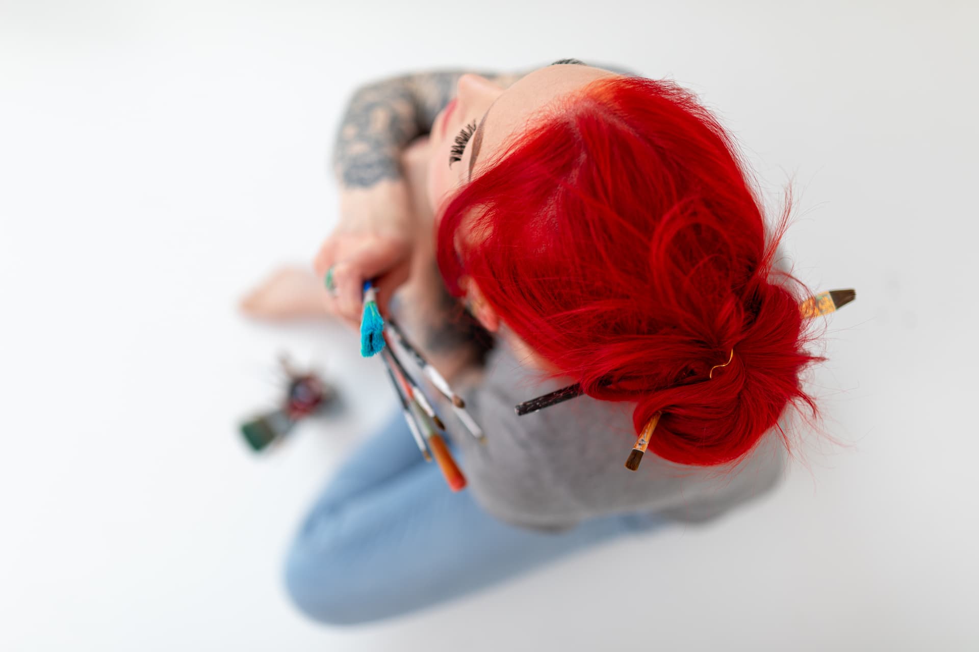 young man wearing shades and a hat with a beard, tattos and ear piercings